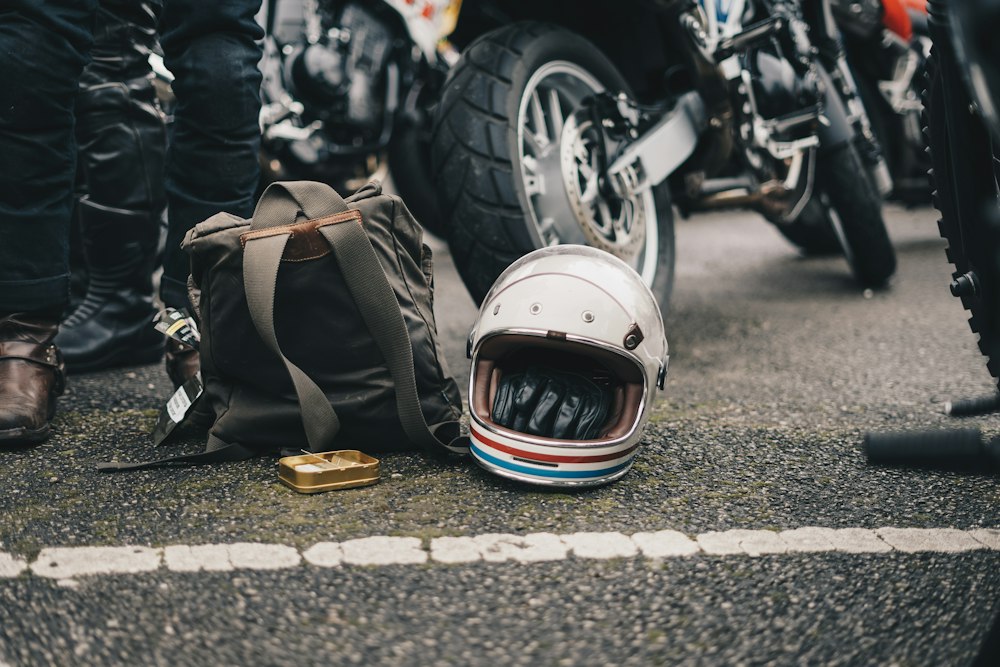 Motorcycle helmet lying on the road beside a downed motorcycle