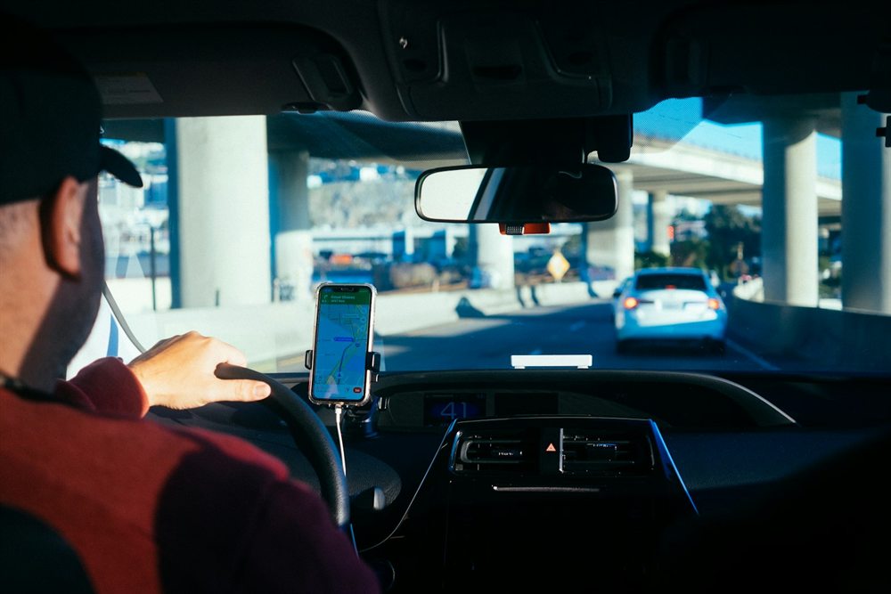 Rideshare driver using a navigation app on the road
